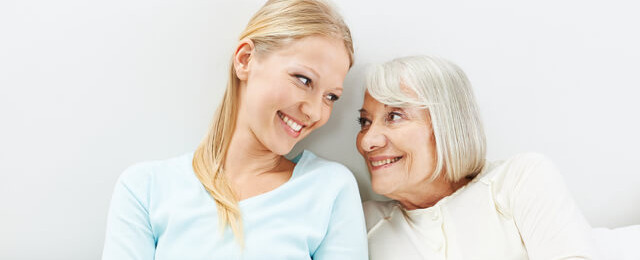 Blonde Frau und eine ältere Frau schauen lächelnd