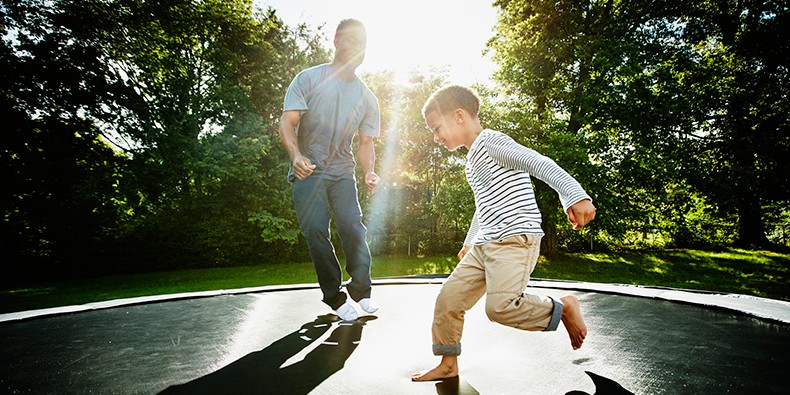 Vater mit seinem Sohn auf einem Trampolin
