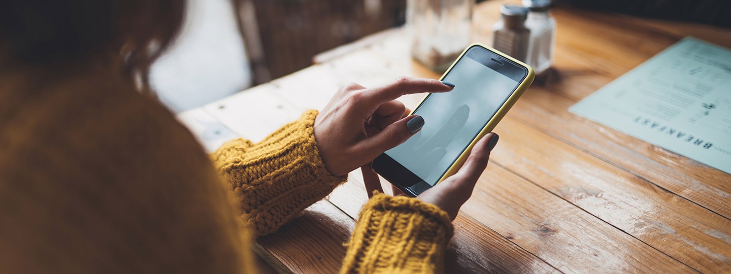 Frau tippt auf ihrem Smartphone