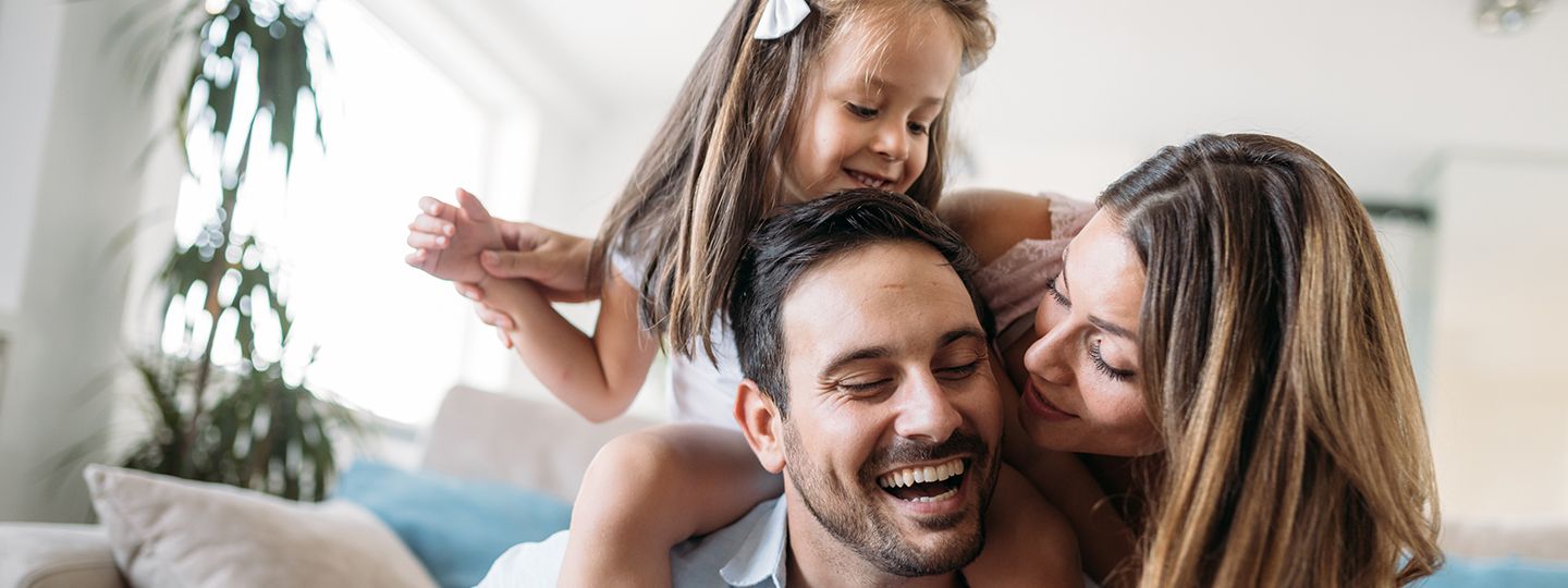 Junge Familie in ihrer durch eine Haftpflichtversicherung der Öffentlichen abgesicherte Wohnung