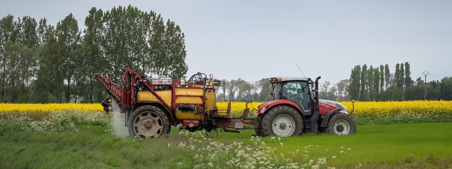Traktor bei Feldarbeit – Ertragsausfallversicherung für landwirtschaftliche Betriebe und sichere Ernten