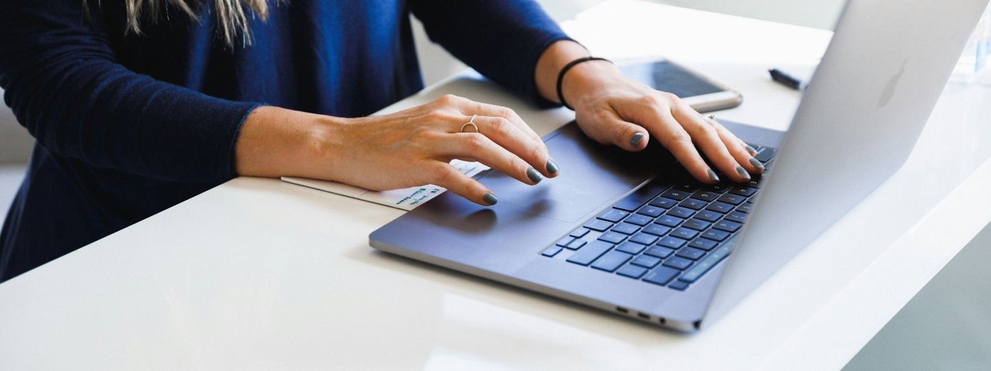 Frau meldet sich via Laptop beim Kundenportal der Öffentlichen Versicherung Braunschweig an