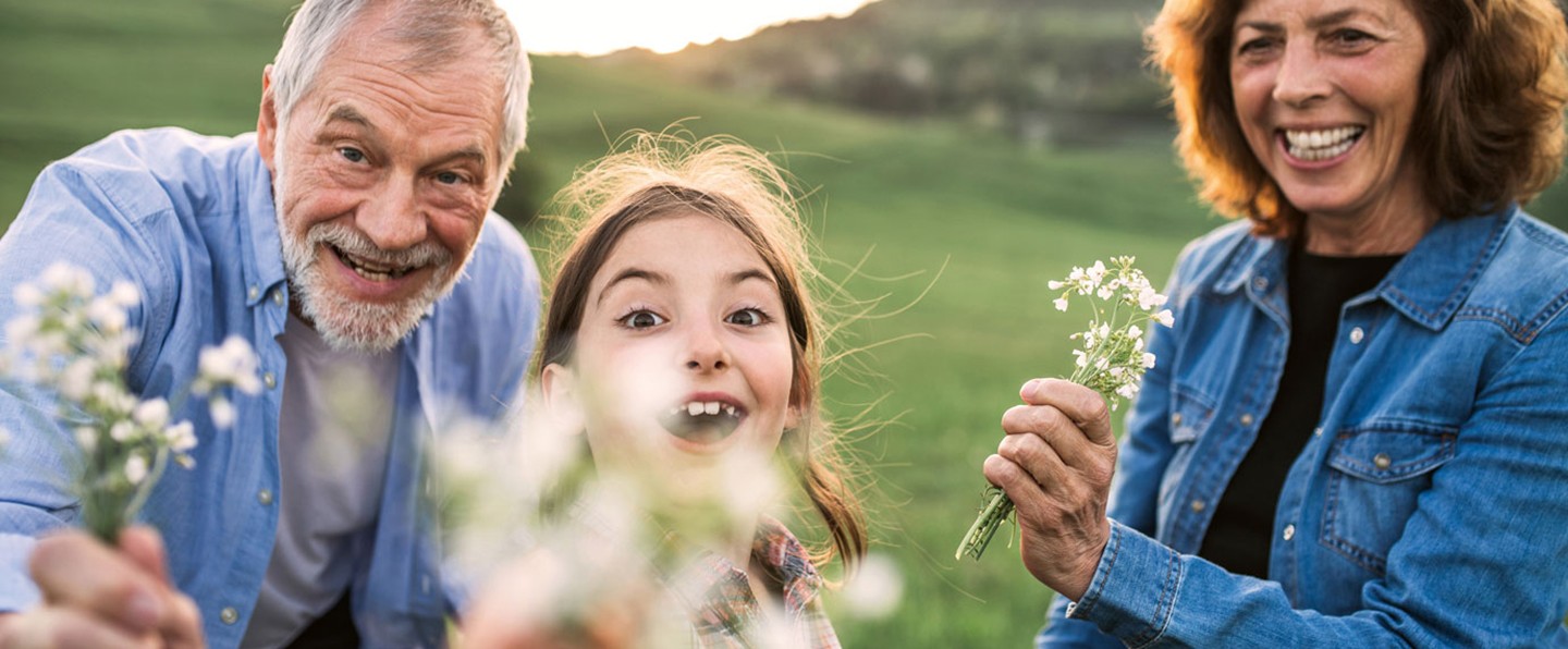 Großeltern mit ihrer Enkelin am Blumen pflücken