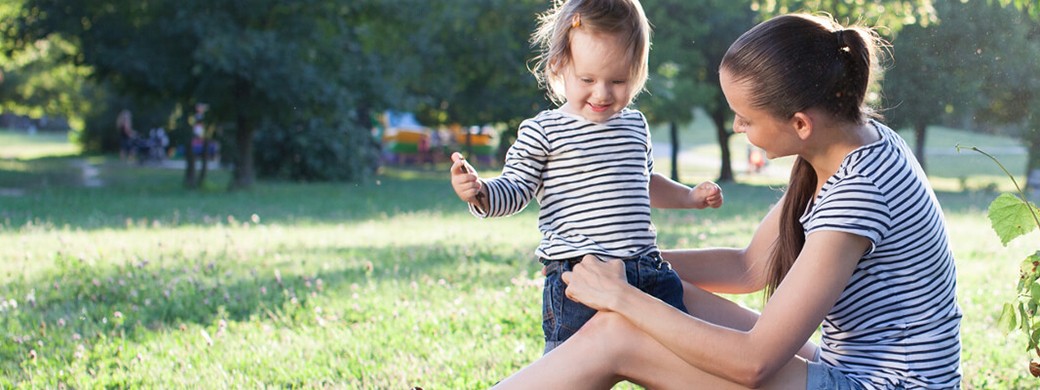 Mutter spielt mit ihrem Kind im Park und genießt gemeinsame Zeit in einem sicheren Umfeld
