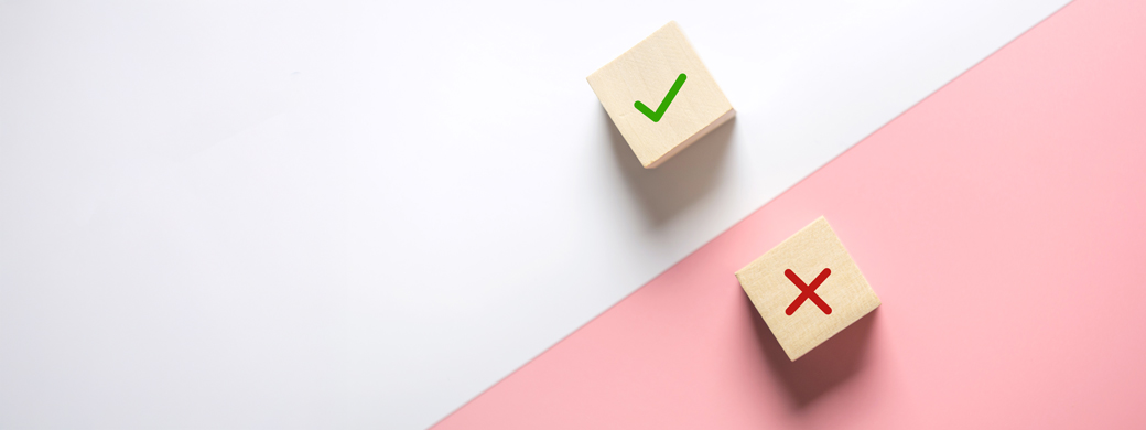 Würfel mit grünem Haken und rotem Kreuz