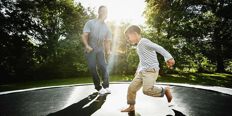 Vater mit seinem Sohn auf einem Trampolin
