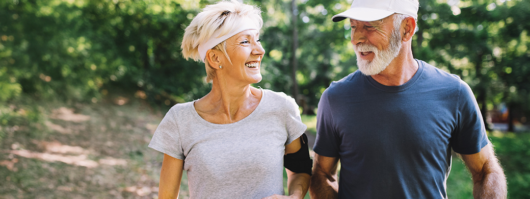 Älteres Paar unterhält sich beim Walken über ihre Vorsorgeversicherung bei der Öffentlichen
