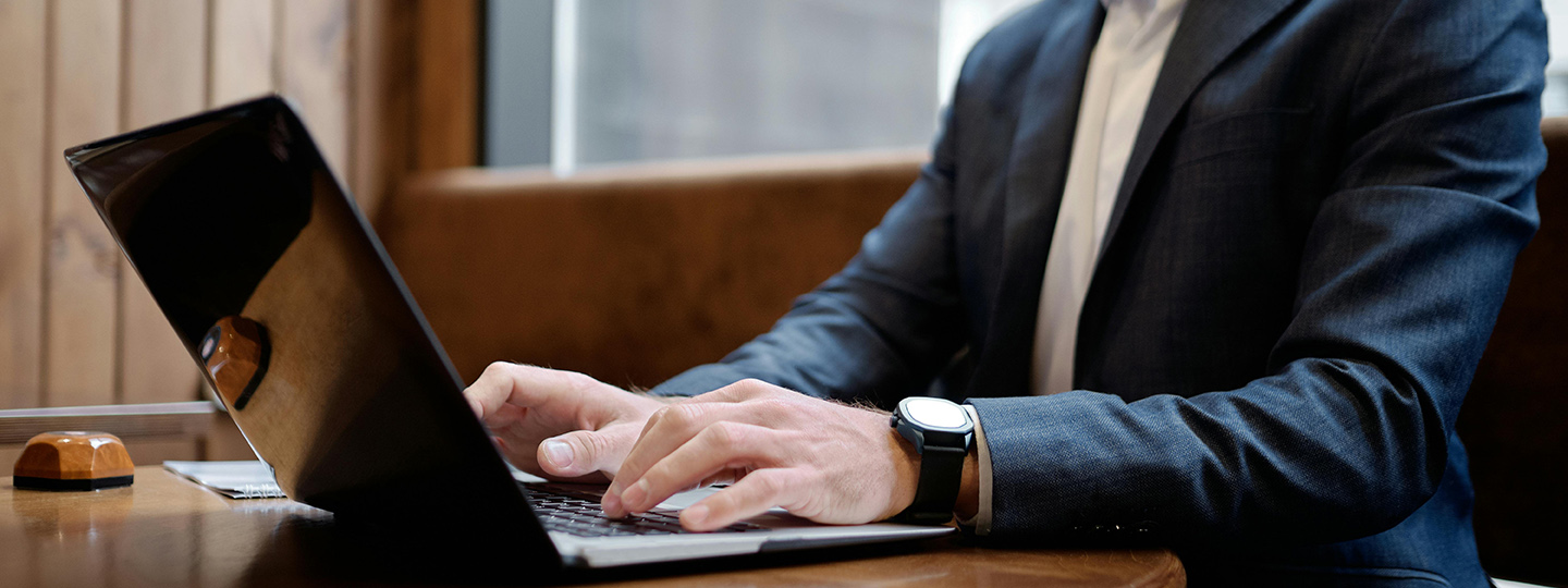 Mann sitzt an seinem Laptop