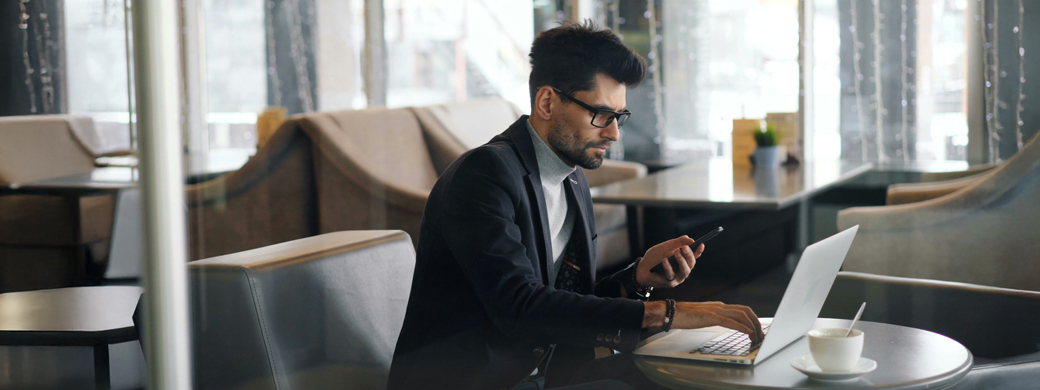 Mann sitzt am Laptop und beantragt eine Kreditversicherung der Öffentlichen