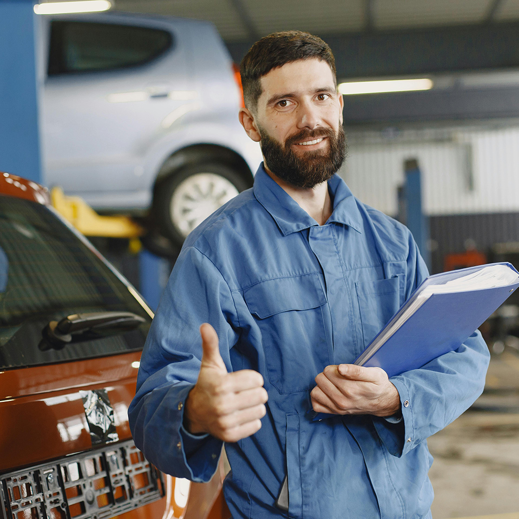 Mechaniker in der Werkstatt zeigt Daumen hoch