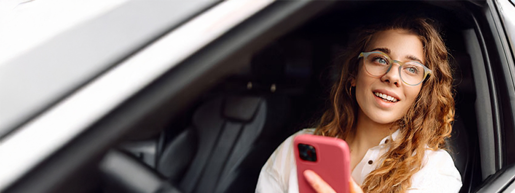 Frau informiert sich an ihrem Smartphone über den Kfz-Service der Öffentlichen Versicherung Braunschweig