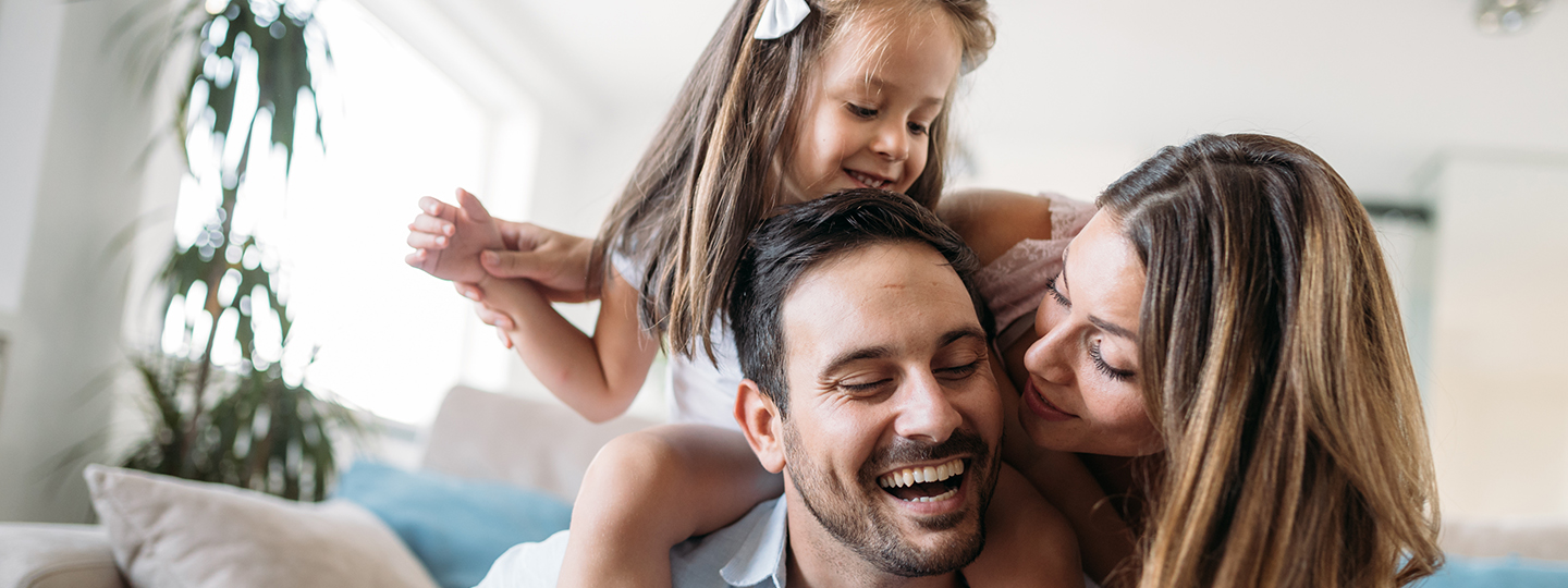 Junge Familie in ihrer durch eine Haftpflichtversicherung der Öffentlichen abgesicherte Wohnung