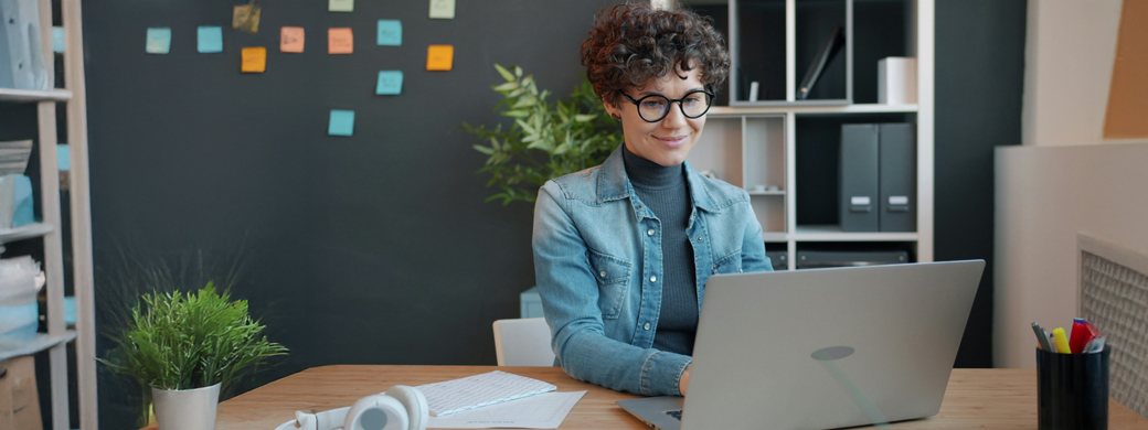 Frau sitzt am Laptop und beantragt eine Bürgschaft der Öffentlichen