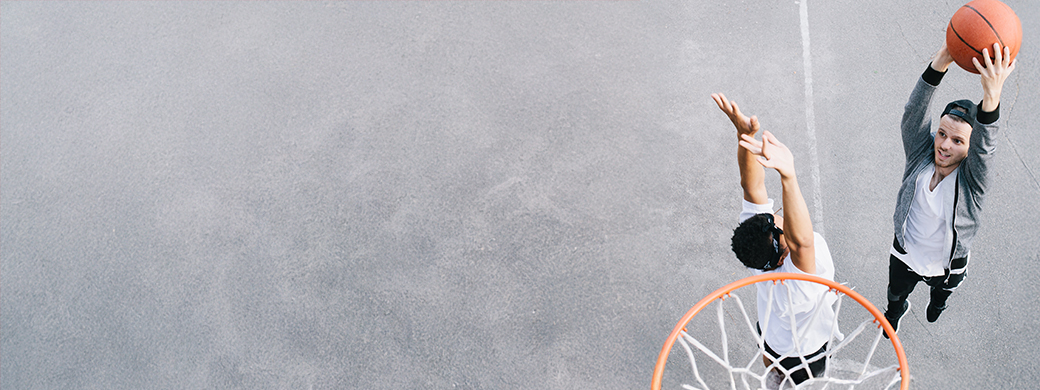 Junger Mann denkt beim Basketball spielen über Gesundheitsschutz bei der Öffentlichen nach