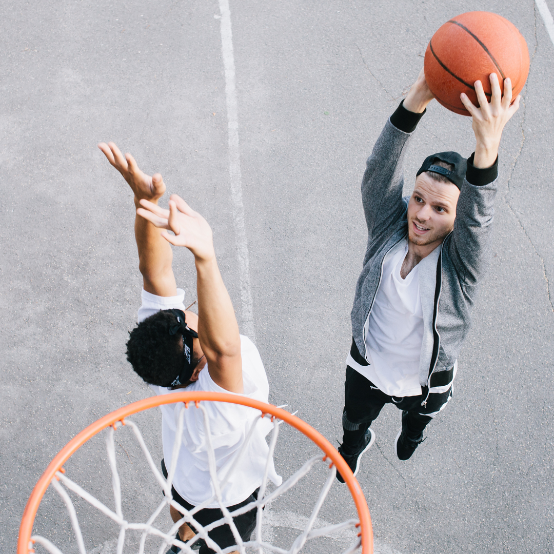 Mann denkt beim Basketball spielen über Gesundheitsschutz bei der Öffentlichen nach