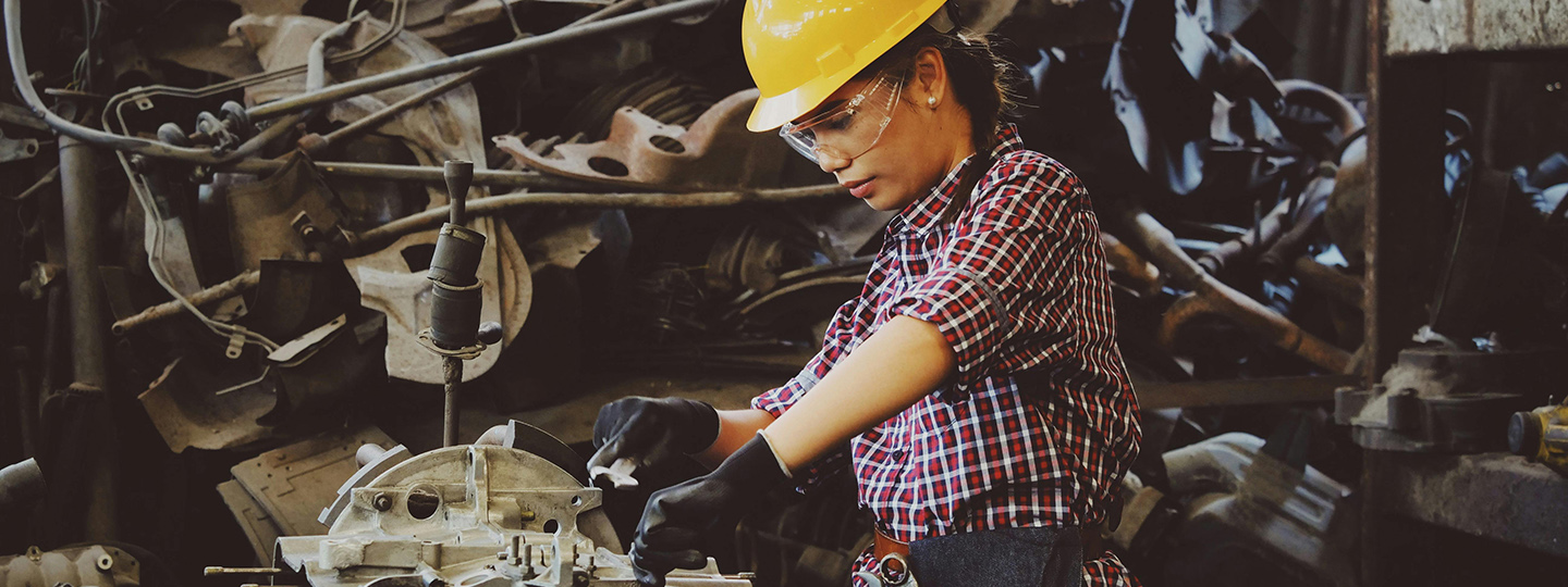Frau mit Helm an der Maschine