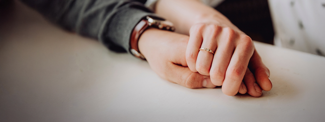 Frau hält Hand des Partners nach dem Abschluss einer Risiko-Lebensversicherung