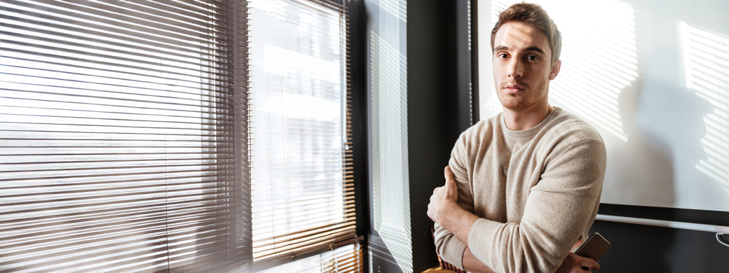 Mann steht vor dem Fenster in seinem Geschäft