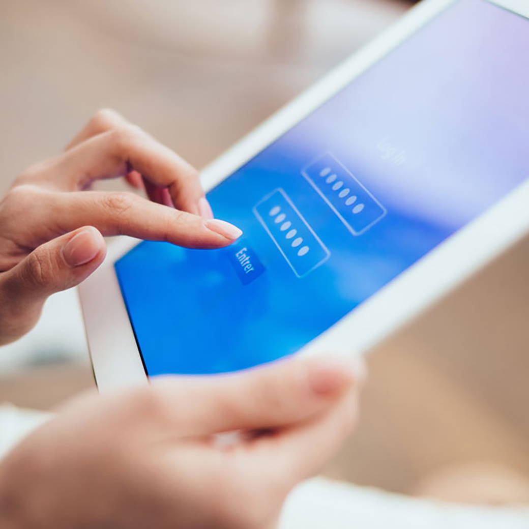 Frau tippt Login-Daten am Tablet ein