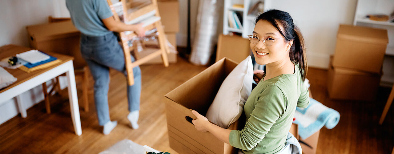 Eine Frau bereitet Ihren Umzug mit den Umzugskartons der Öffentlichen Versicherung Braunschweig vor