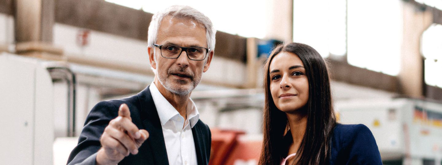 Mann in einer Maschinenhalle informiert sich am Laptop zur FirmenRente der Öffentlichen