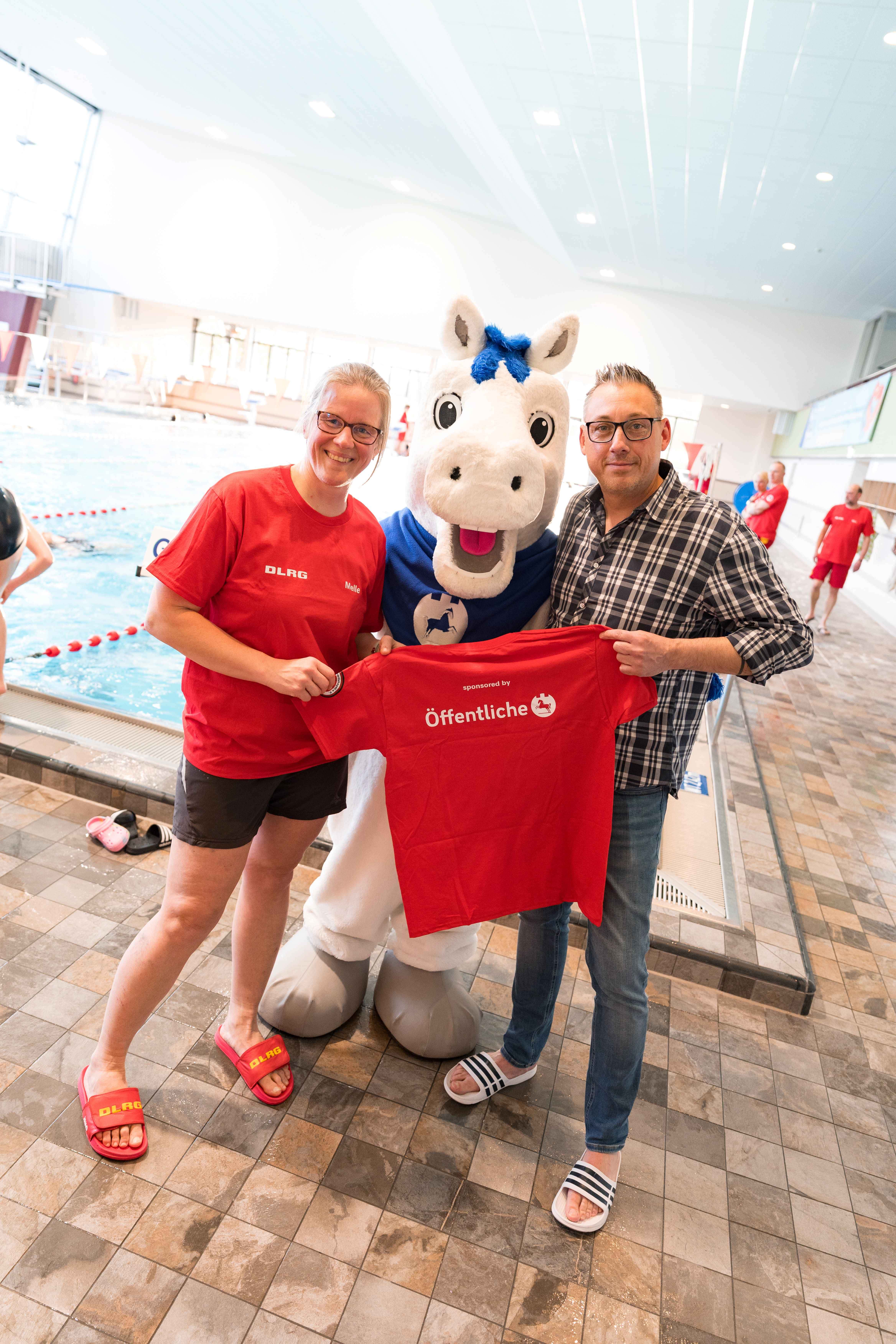 Britta Waßmuß und die Ortsgruppe der DLRG aus Gebhardshagen freuen sich über 50 von der Öffentlichen gesponserte T-Shirts im Stadtbad in Lebenstedt