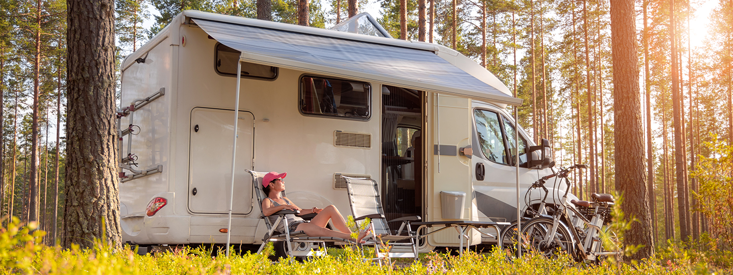 Campingfahrzeug mit Markise steht im Wald