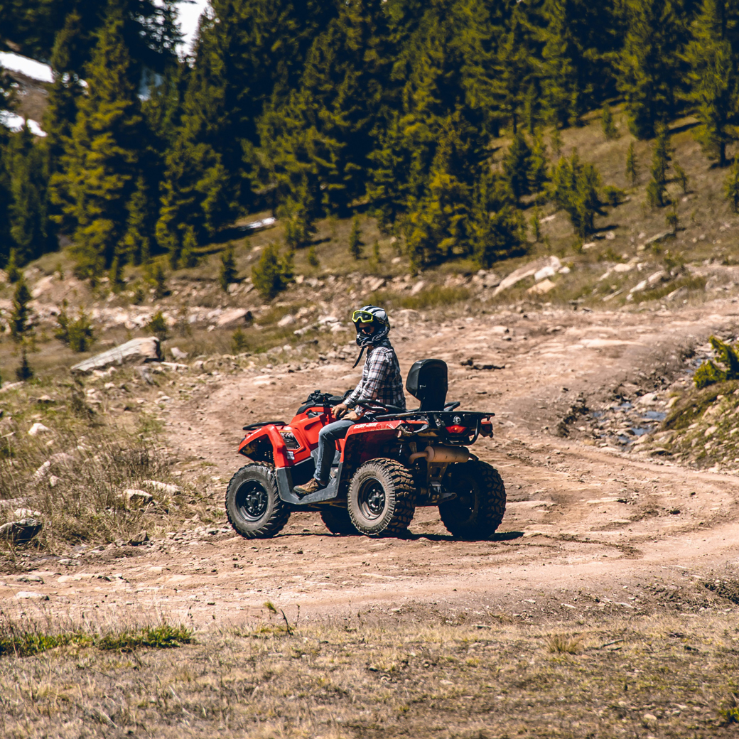 Kunde der Öffentlichen Versicherung Braunschweig fährt mit seinem Quad auf einem Waldweg