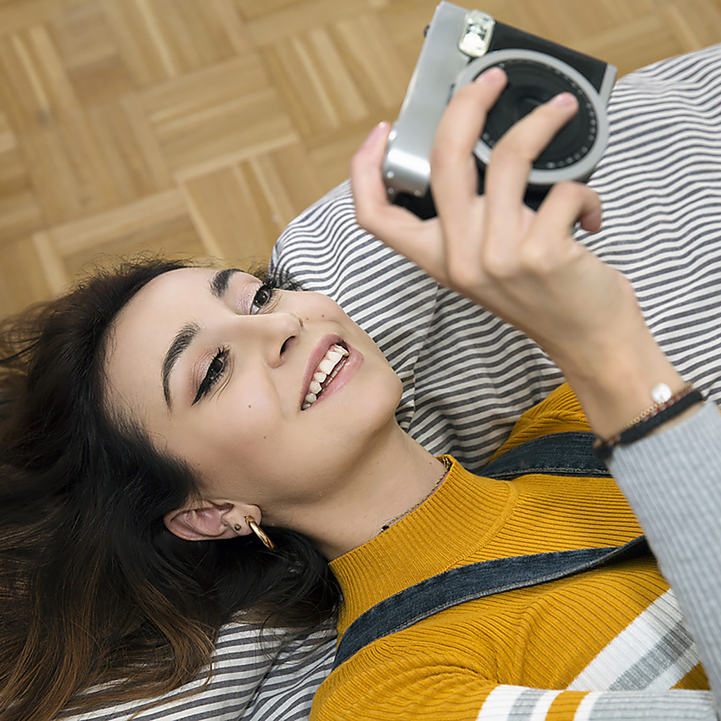Junge Dame mit liegt auf dem Sofa mit einer Kamera in der Hand