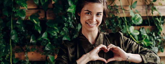 Symbolbild mit einer Frau, die Hände zu Herz formt zum Nachhaltigkeitsengagement der Öffentlichen Versicherung Braunschweig