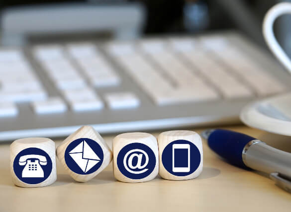 Kontaktsymbole auf einem Schreibtisch mit Tastatur