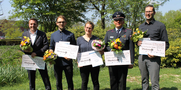 Draußen sind Personen mit Auszeichnung und Blumenstrauß in der Hand