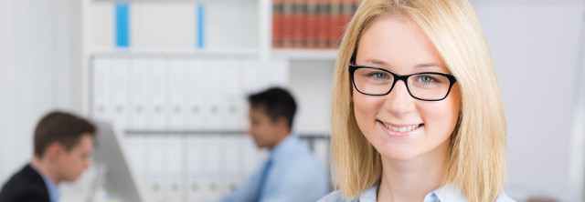 Blonde Frau mit Brille im Büro