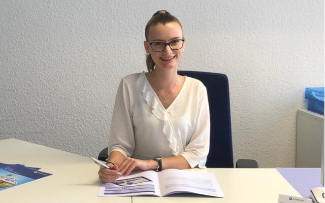 Portraitfoto Lana Gregson sitzend am Schreibtisch 